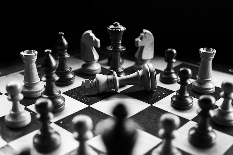 Chess pieces on a dark board with the king toppled mid-game
