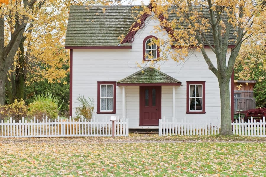A family home in autumn, porch framed by golden leaves